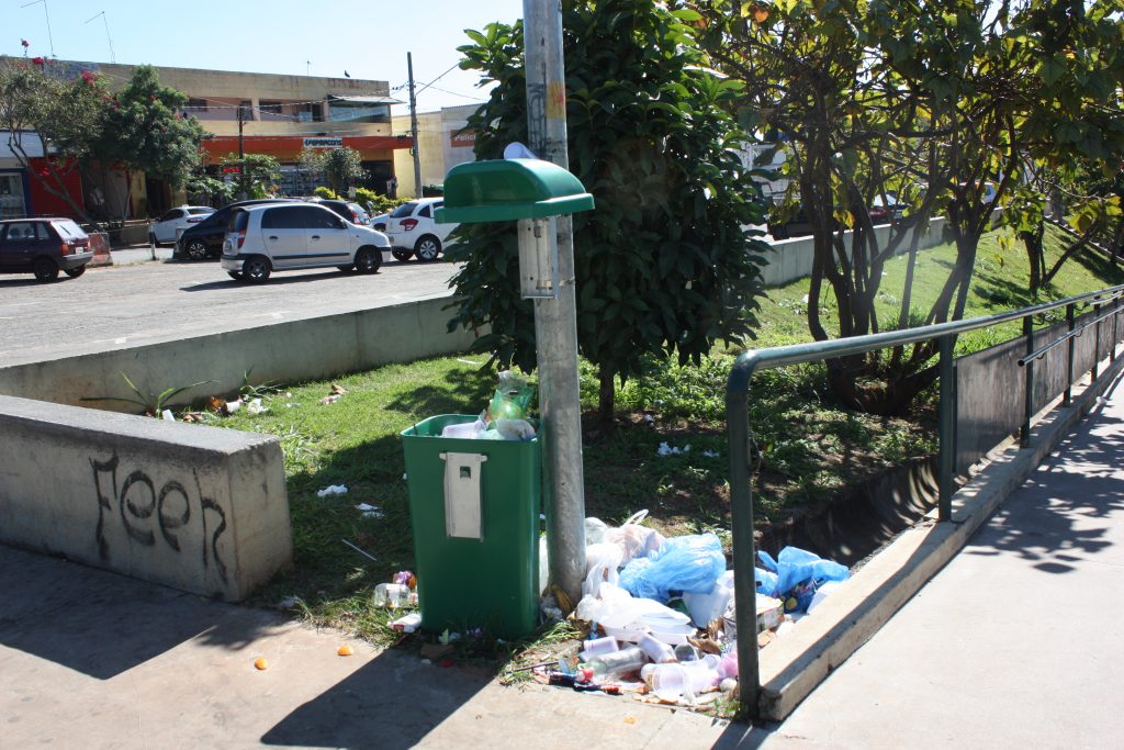 Lixeira quebrada e lixo acumulado